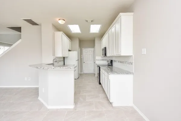 a utility room with cabinets washer and dryer