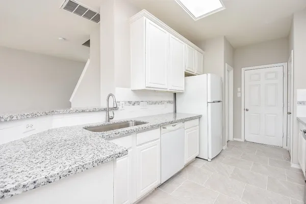 a kitchen with stainless steel appliances granite countertop a sink and a refrigerator