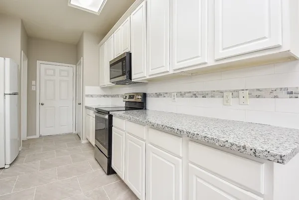 a kitchen with stainless steel appliances granite countertop a sink and a stove