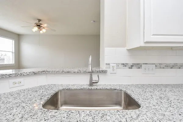 a kitchen with a sink and a granite counter tops