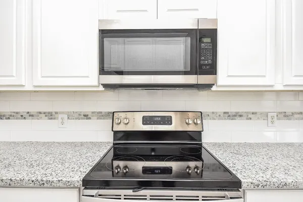 a stove top oven sitting inside of a kitchen