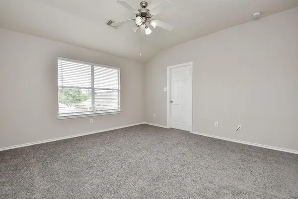 an empty room with a window and ceiling fan