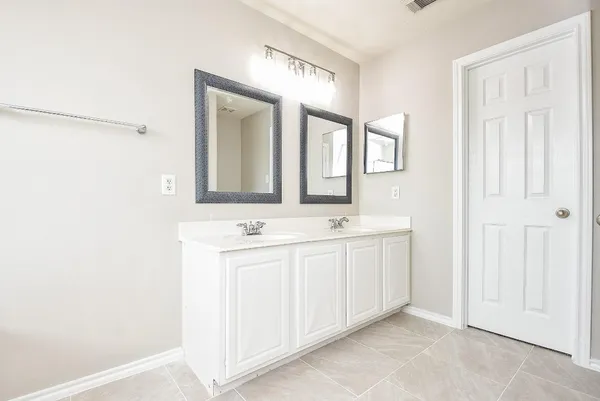 a bathroom with a double vanity sink and mirror