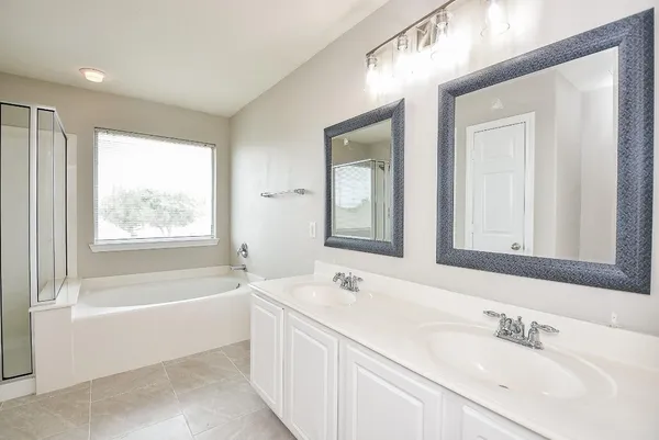 a bathroom with a bathtub a sink and a window