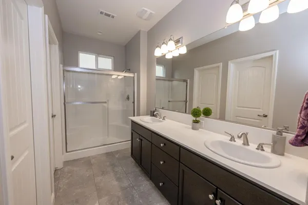 a spacious bathroom with a double vanity sink mirror and shower