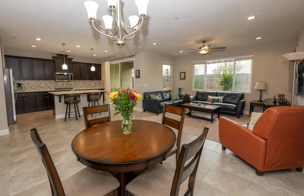 a large dining space with furniture a rug and a chandelier