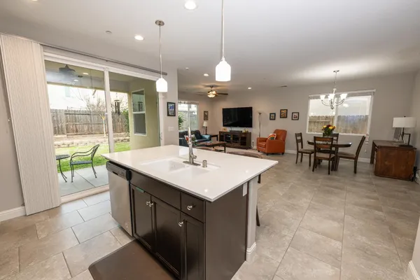 a kitchen with kitchen island a sink dining table and chairs