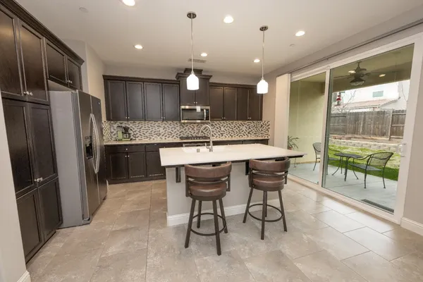 a kitchen with kitchen island granite countertop a table and chairs in it