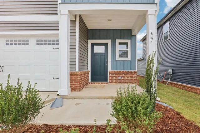 a view of a house with basketball space and a yard