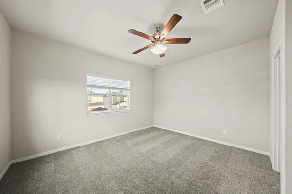 an empty room with a window and a fan