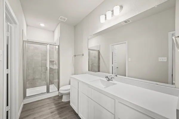 a bathroom with a sink a toilet and shower