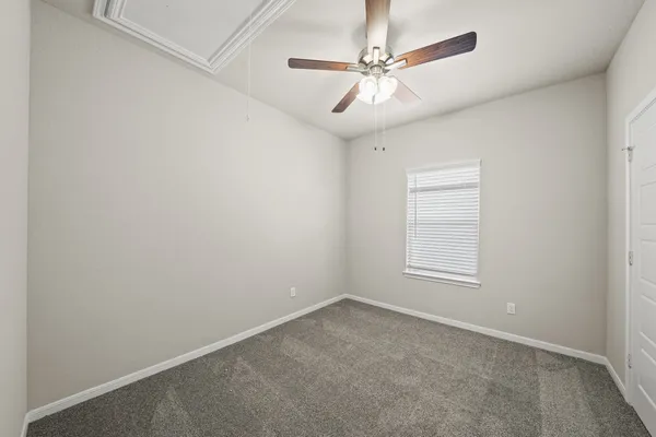 an empty room with windows and fan