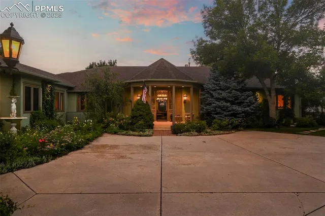 a view of a house with a small yard and potted plants