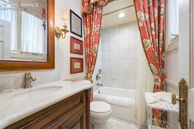 a bathroom with a granite countertop toilet a sink and a bathtub