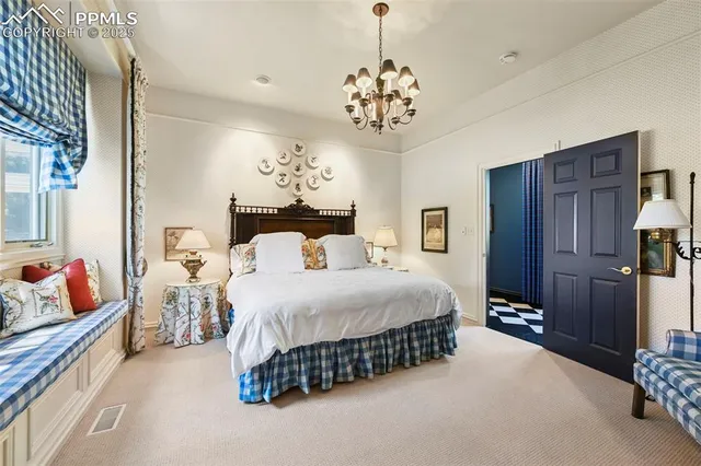 a bedroom with a bed and a chandelier