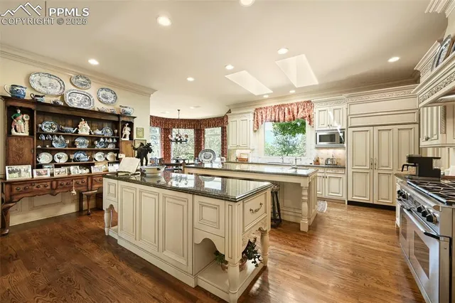 a kitchen with stainless steel appliances granite countertop a stove a sink and a refrigerator