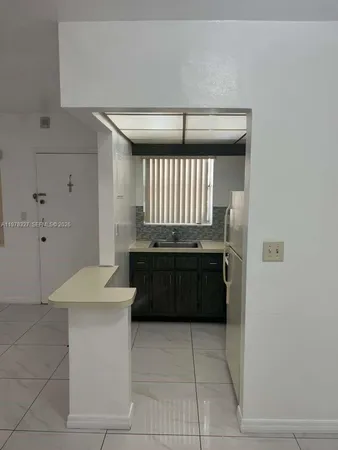 a kitchen with a refrigerator and a sink