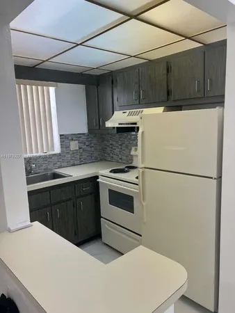 a kitchen with a refrigerator and a stove top oven