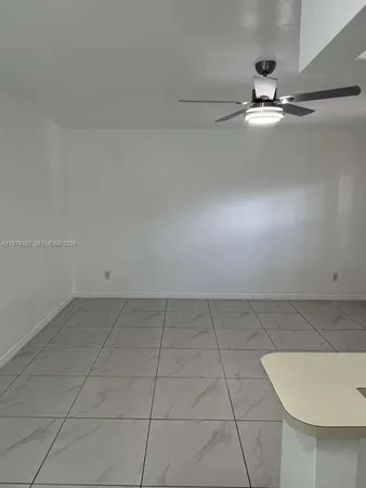 a view of a room with window and chandelier fan