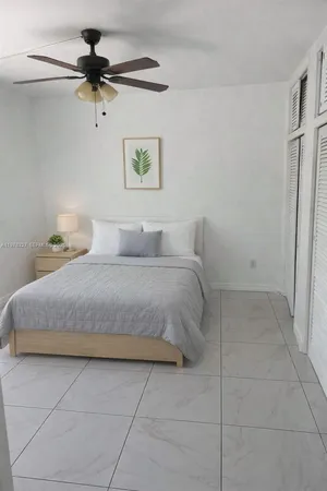 a bedroom with a bed and a ceiling fan