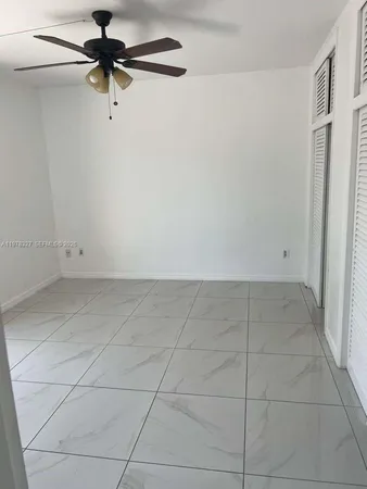 a view of room with a ceiling fan and a window