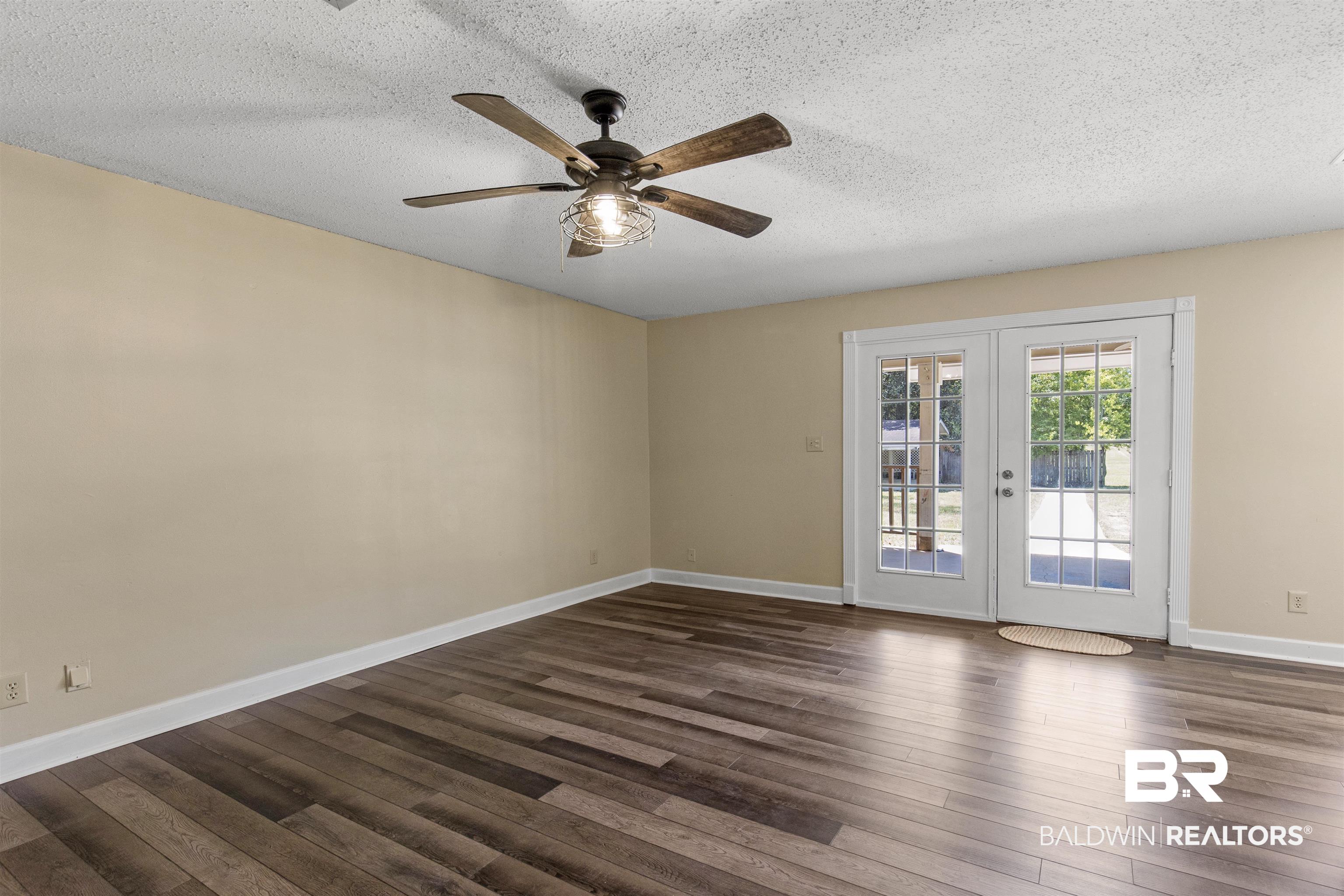 5665 Ulysses Road Eight Mile, AL 36613 - Photo 2 of 23 Unfurnished room with a ceiling fan, dark wood-style flooring, french doors, and a textured ceiling