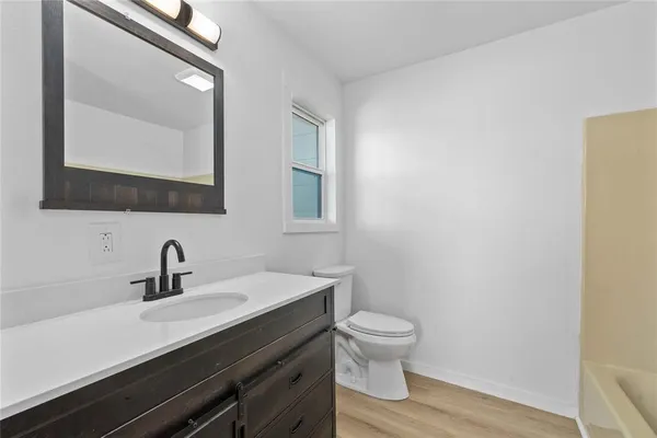 a kitchen with white cabinets stainless steel appliances and wooden floor