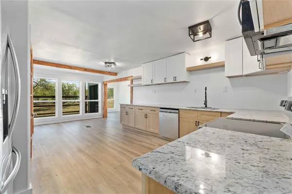 a view of a kitchen with a sink stove cabinets and empty room