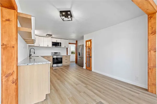 a view of a room with wooden floor and a bathroom