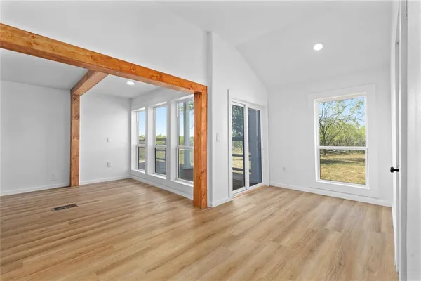 a view of empty room with wooden floor and ceiling fan