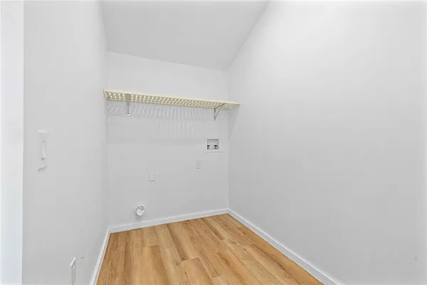 a view of a room with wooden floor and a ceiling fan