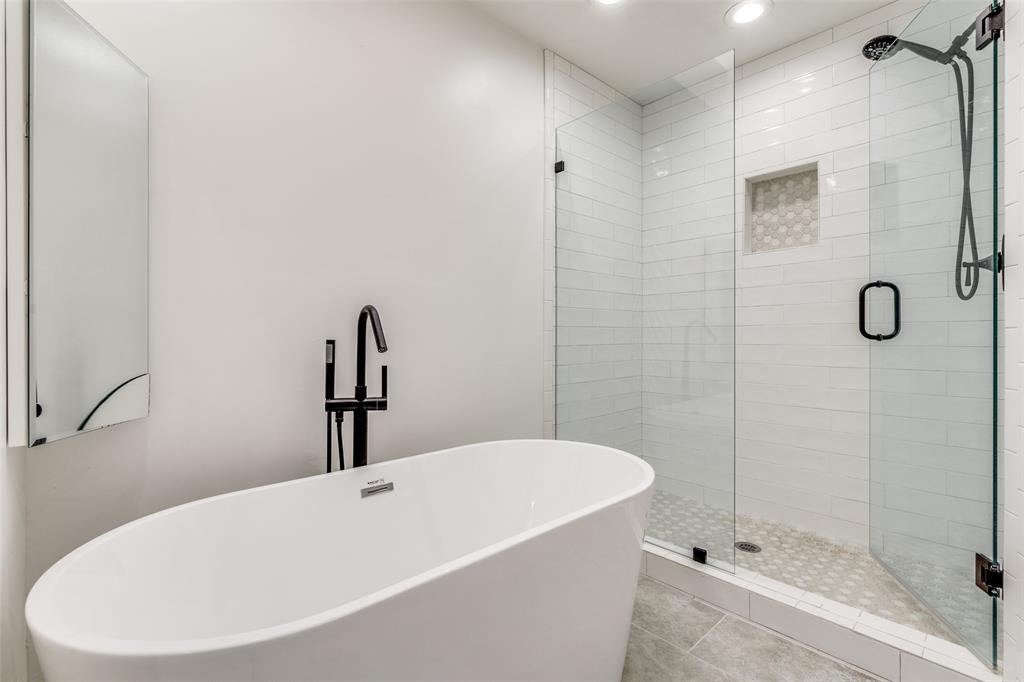 9130 Valley Chapel Lane Dallas, TX 75220 - Photo 26 of 39 a bathroom with a white bath tub and a shower