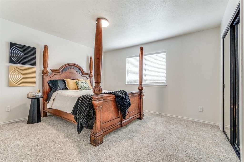 9130 Valley Chapel Lane Dallas, TX 75220 - Photo 28 of 39 a bedroom with a bed and dresser with window