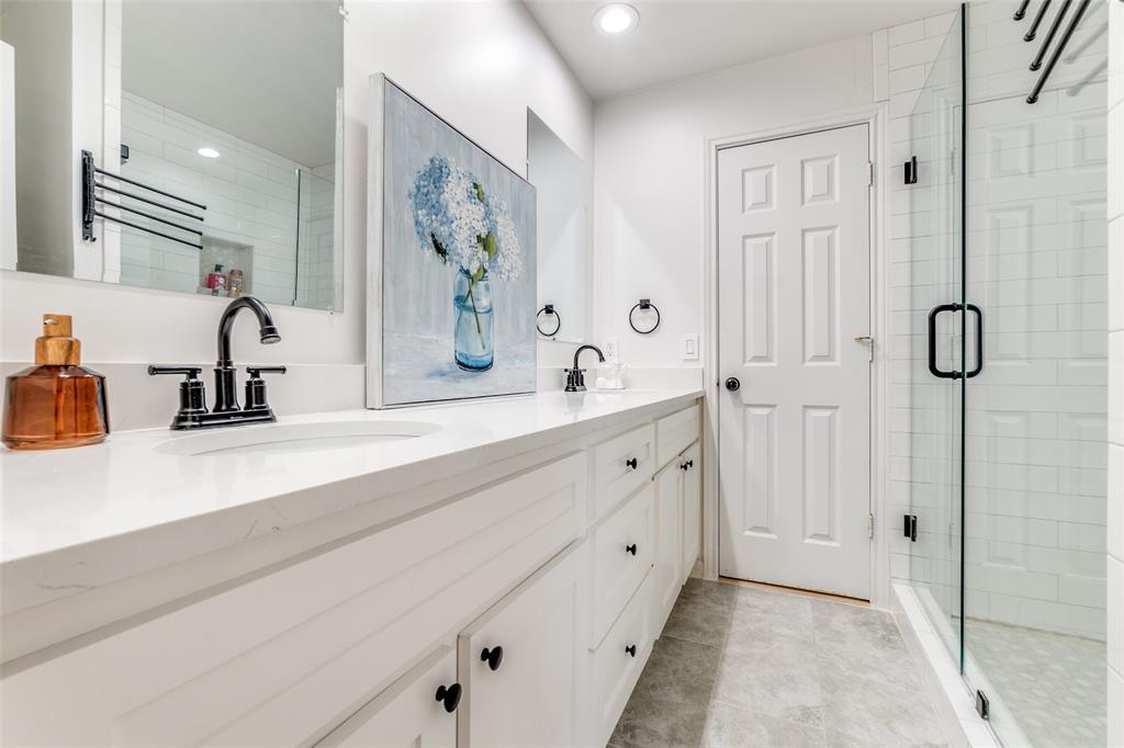 9130 Valley Chapel Lane Dallas, TX 75220 - Photo 29 of 39 a bathroom with double vanity sink a mirror a glass door a shower and vanity