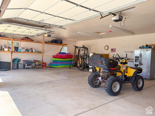 425 East Mule Deer Road Central, UT 84722 - Photo 51 of 72 Garage with stainless steel refrigerator with ice dispenser and a garage door opener