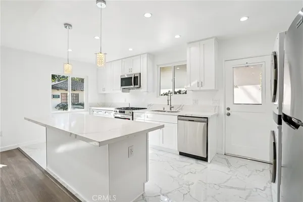 a kitchen with kitchen island a sink appliances and cabinets