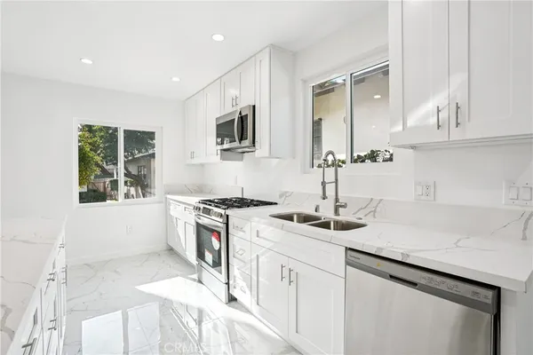 a kitchen with granite countertop a sink stove and cabinets