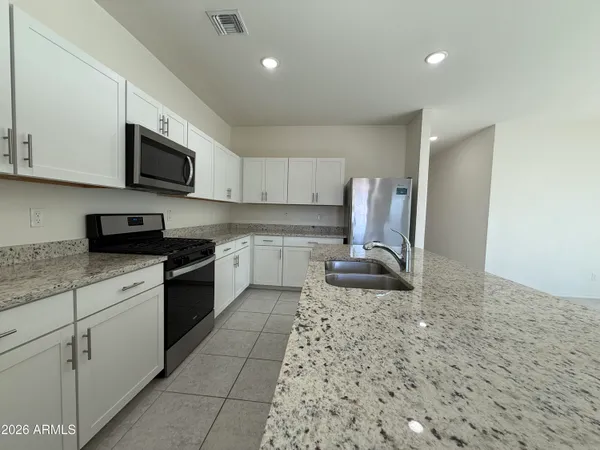 a kitchen with a sink a stove top oven and cabinets