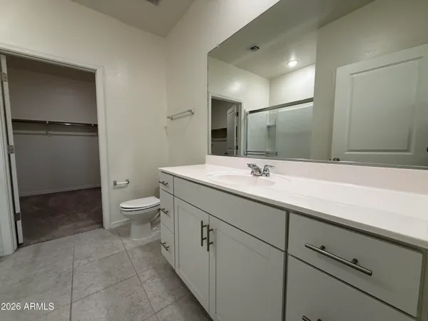 a bathroom with a double vanity sink toilet and mirror