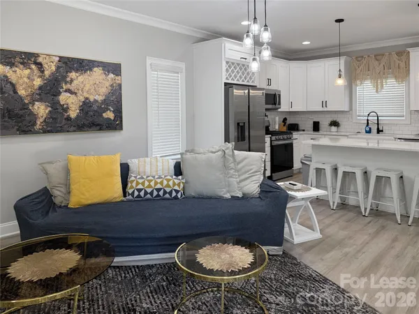 a living room with furniture a refrigerator and kitchen view