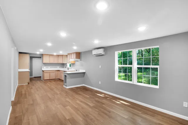 a view of a kitchen with kitchen island a window wooden floor and a counter top space