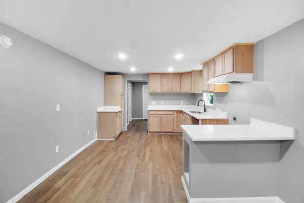 a large white kitchen with a sink a stove and a refrigerator