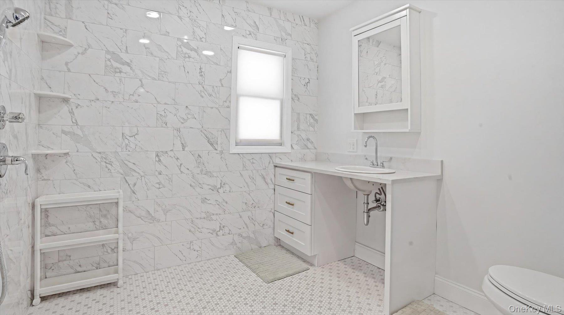 32 Red Creek Road Hampton Bays, NY 11946 - Photo 13 of 18 a bathroom with a sink a toilet and shower