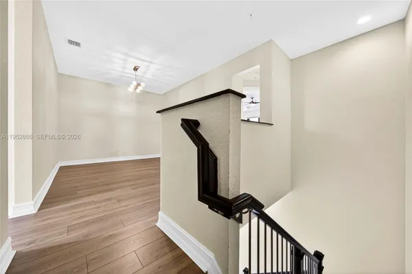 a view of a hallway with wooden floor and staircase