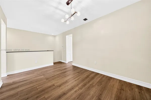 a view of an empty room with wooden floor