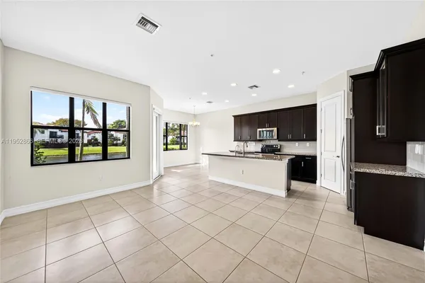 a large white kitchen with a stove a refrigerator and a sink