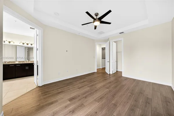 a view of a big room with wooden floor and a ceiling fan