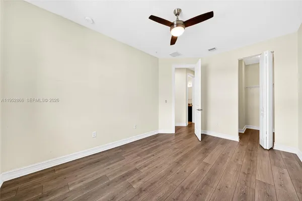 an empty room with wooden floor and windows