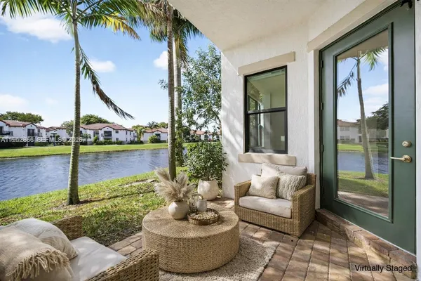a living room with patio furniture and a potted plant