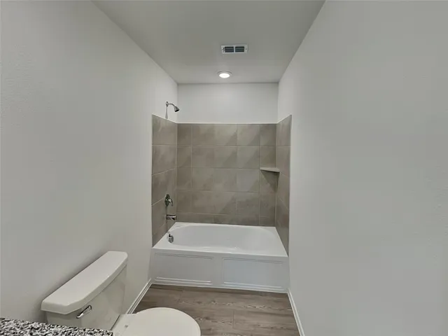a bathroom with a toilet and a bath tub